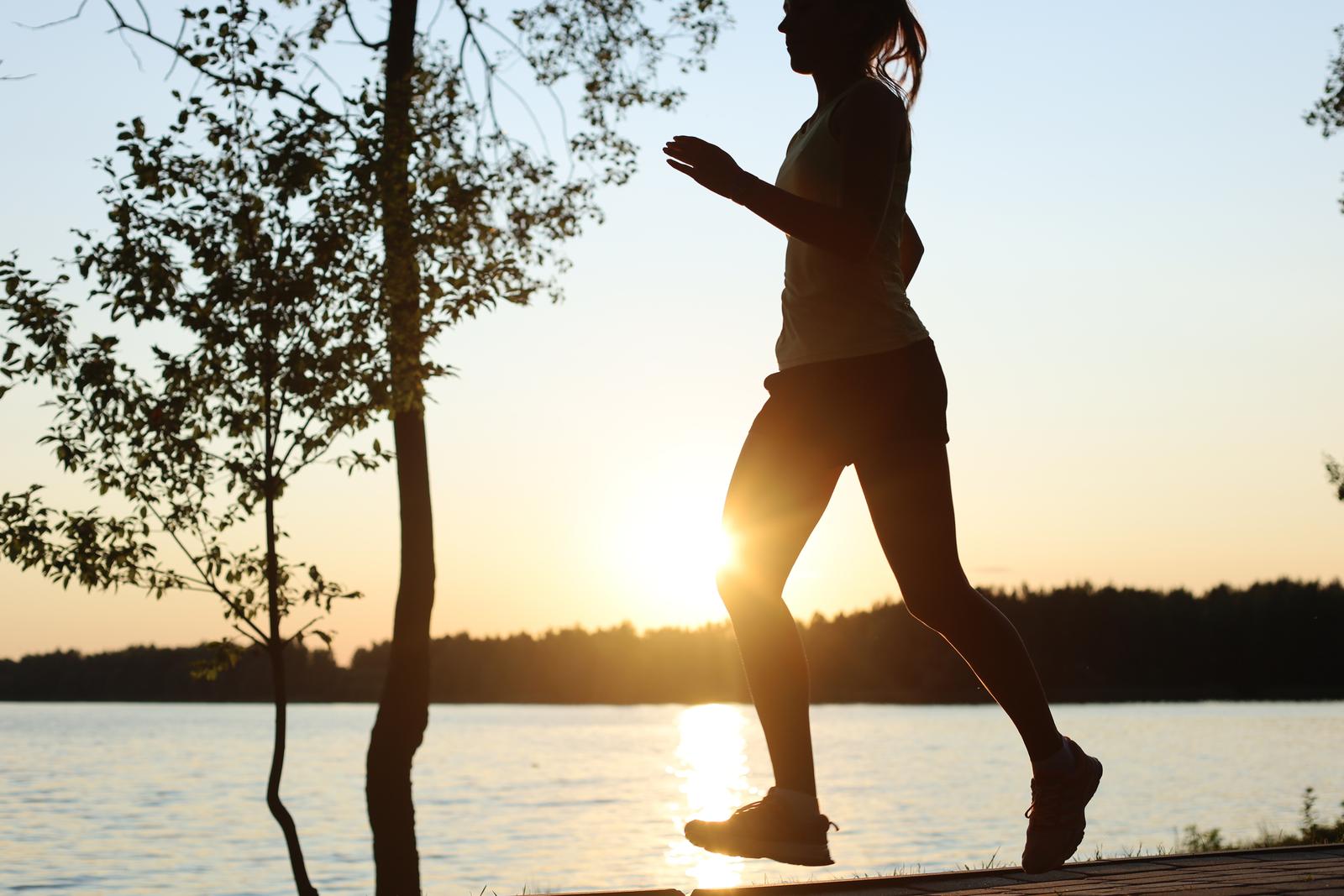 Sporty female jogger running and training outside in nature